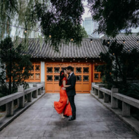 Woman in red dress dancing with groom after beautiful Chinese tea ceremony wedding