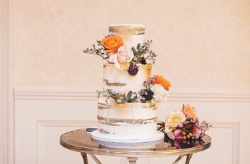 Gorgeous white wedding cake with gold leaf paint 3 layers fresh orange flowers
