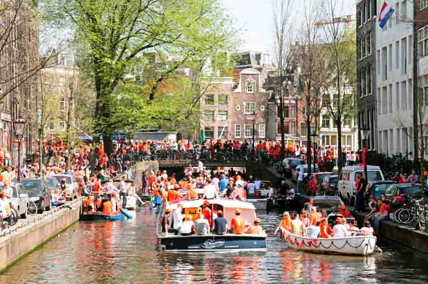 AMSTERDAM - APRIL 30: Amsterdam canals full of boats and people