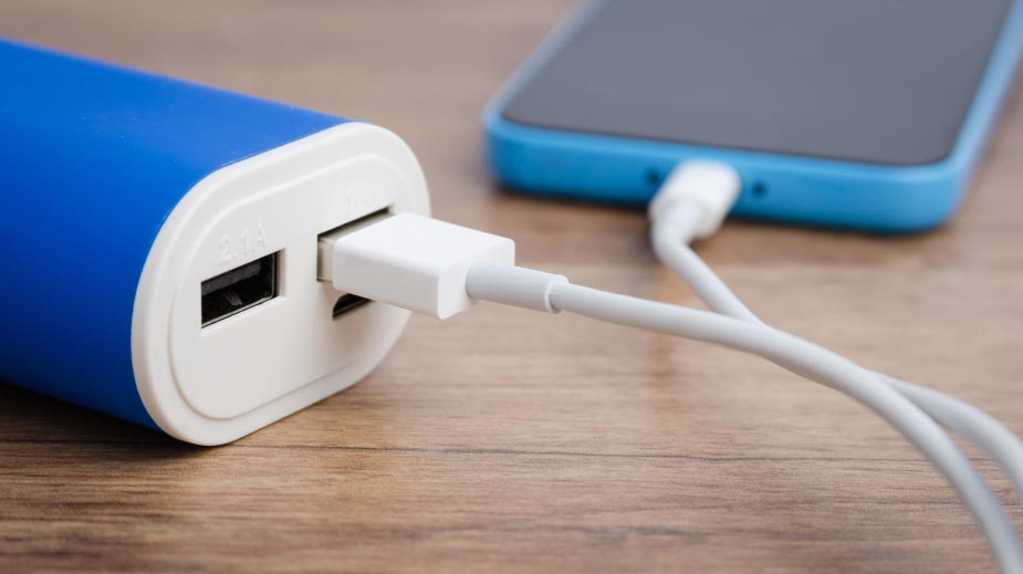 Charging a smartphone from powerbank on wooden table