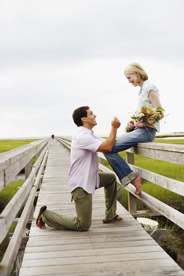 Man proposing to woman on walkway