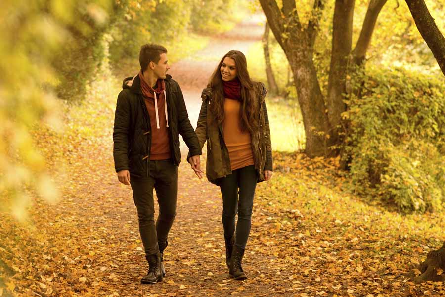 Lovers walking holding hands in autumn park