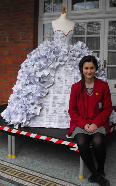 Demi Barnes of West Sussex, England, with her inventive creation, a wedding dress made from divorce papers. Image: Lingfield Notre Dame School