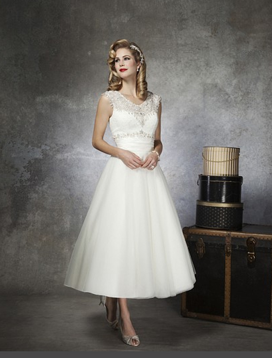 From Justin Alexander, this tea length wedding gown combines the past with the present. It's retro styling is detailed and delicate enough to suit a vintage wedding, but not so overbearing that it would be out of place in a more modern celebration.