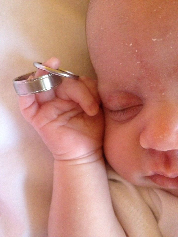 baby holding wedding rings
