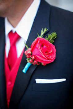 a groom wearing a red rose in jacket pocket