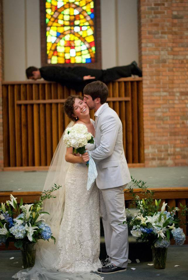 priest planking while newlyweds are photographed
