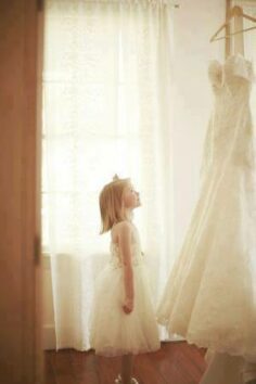little girl looking at wedding dress