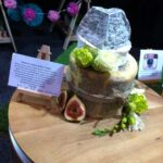 A medium-sized cheese wheel tower complete with sliced figs and grapes. Yumbo! It's from Burnt Butter.