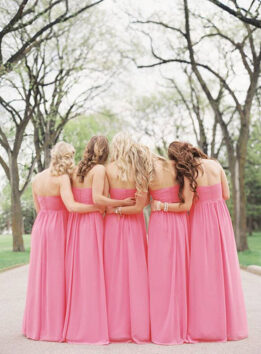 bridesmaids wearing pink dresses and hugging