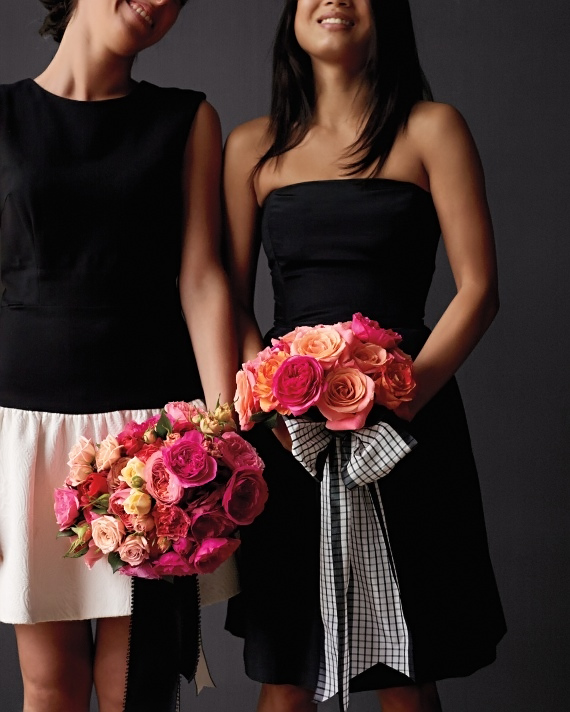 bridesmaids in black dresses with vibrant bouquets of roses