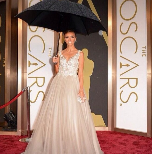 E! News host Giuliana Rancic sports the perfect accessory at the 86th Academy Awards and its rainy red carpet!