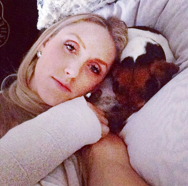 Lara Yunaska with her pet pooch - and one of her two wrist casts. Image: Lara Yunaska via Instagram