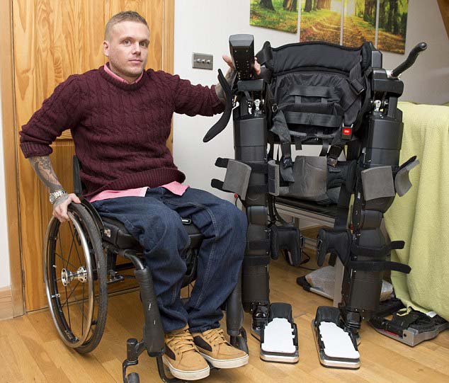 Ben is wheelchair bound after a car accident in 2011 which left him paralysed. He now has the REX walking machine to help him stand and walk. Image Mirrorpix via Daily Mail