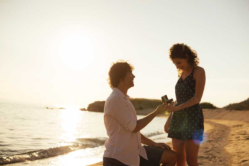 Proposing woman at seaside in summer is romantic