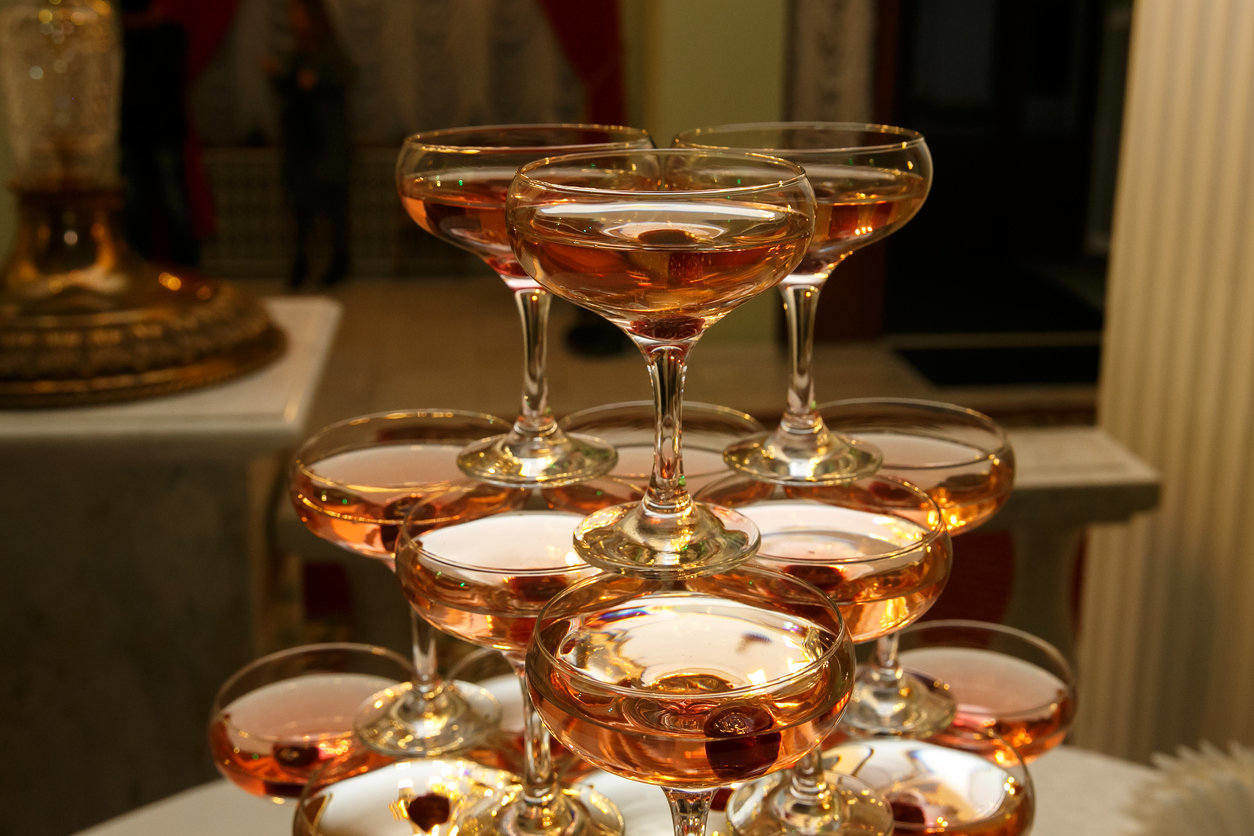 Stack of rose champagne glasses on table in wedding party