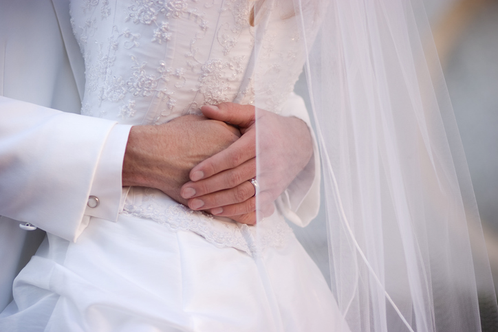 Close Up of Bride and Groom Embracing Wearing White
