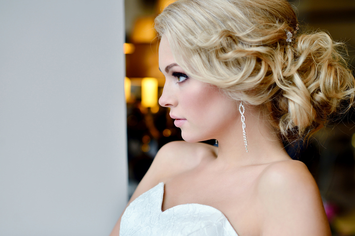 Beauty bride in bridal gown with lace veil indoors