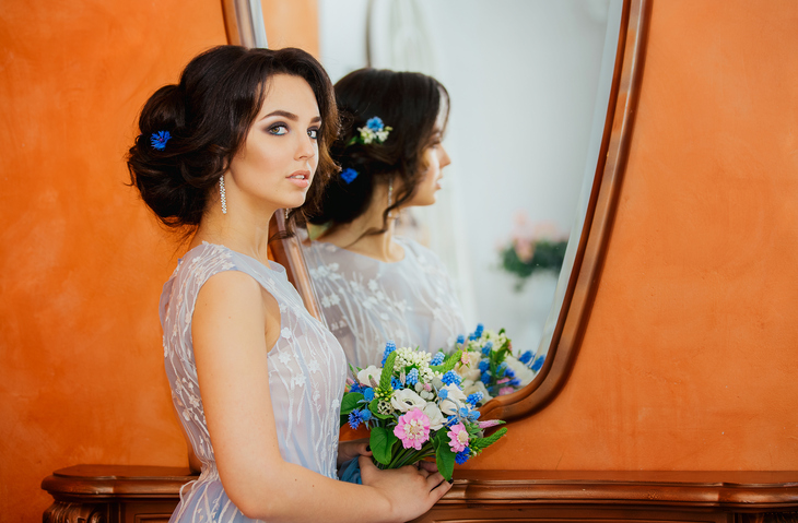 portrait of a young beautiful bride looking in the mirror