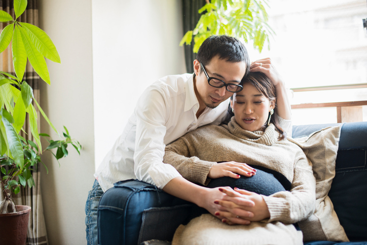 Pregnant woman with her husband in room