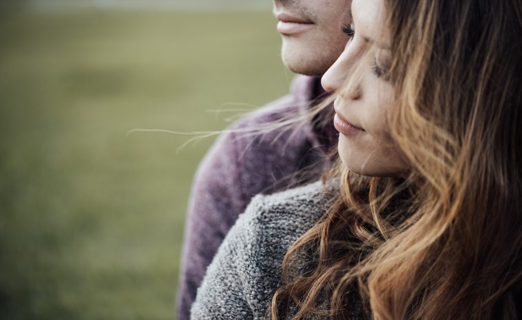 Young loving couple sitting on the grass