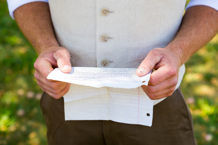 Handsome groom reading his vows for practice before the wedding ceremony.