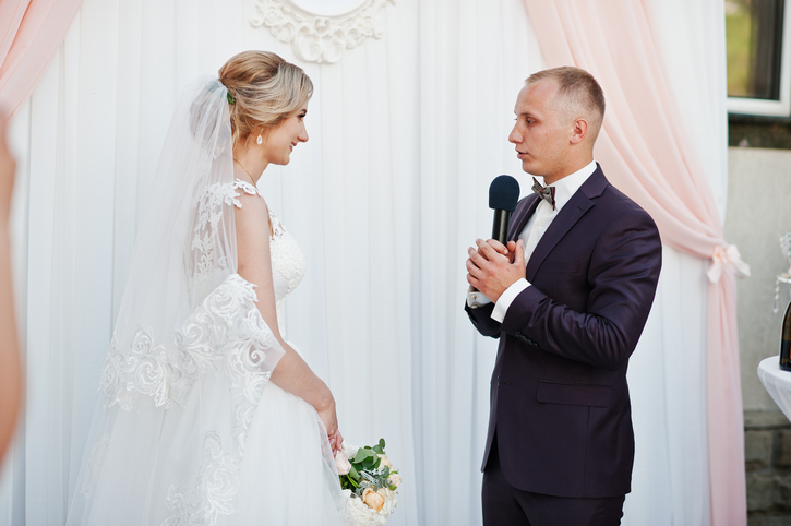 Groom speech, talking with microphone for his bride at wedding ceremony.