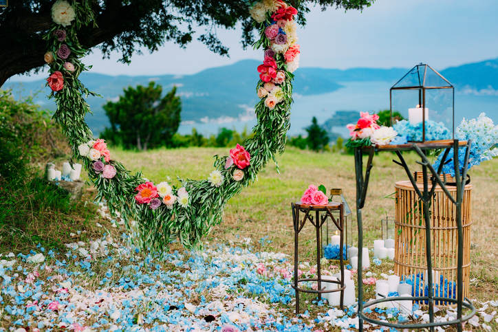 Round wedding arch of flowers and olive branches. Hanging on the