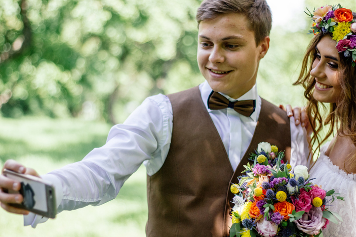Young couple - bride and groom making selfie during wedding ceremony.