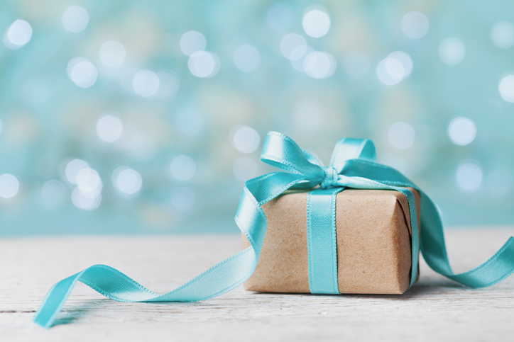 Christmas gift box against turquoise bokeh background. Holiday concept.