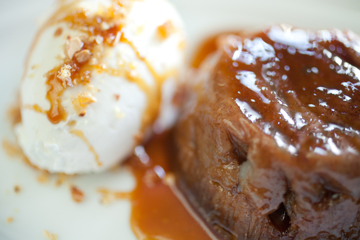 A close-up shot of persimmon pudding with sauce