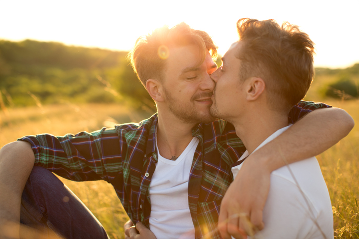 Young gay couple in a meadow.