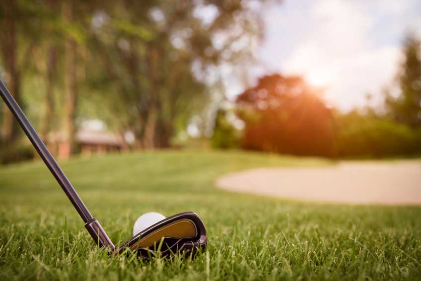 Close up of golf club and ball.