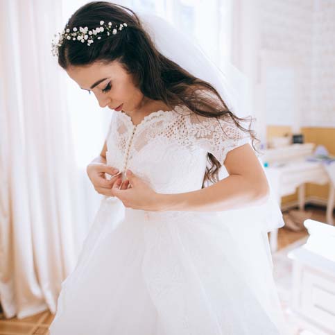 Beautiful bride in bedroom. Last preparations for the wedding.