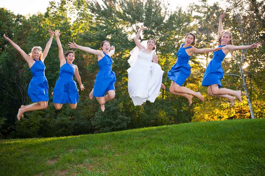 Portrait Of Bridesmaid And Bride Jumping