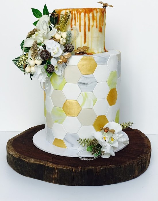 Geometric bee hive design incorporating all the colours in the wedding & featuring a caramel honey drip tier. Image Creative Cakes by Sharon