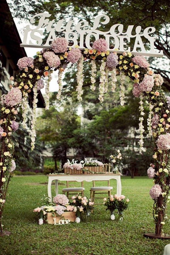 Vintage tables and matching chairs adorned with flowers can be the perfect backdrop for your altar. Image: Inspired by Love Events