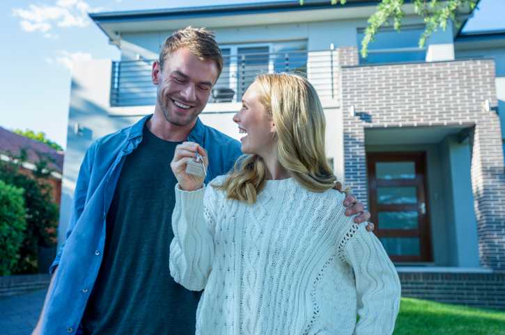 Young couple holding their new house key.