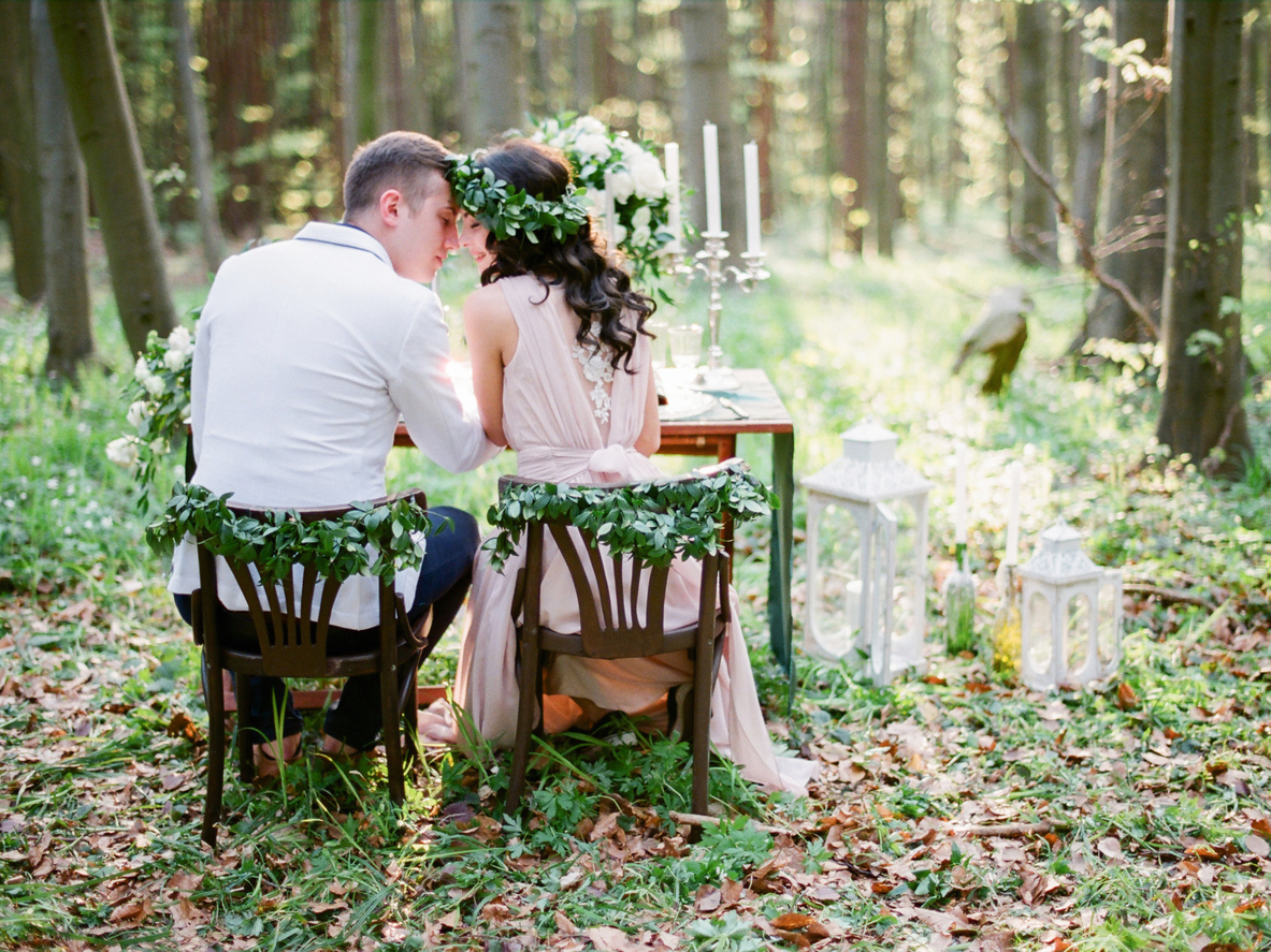 Groom and bride sitting at the table setted for two