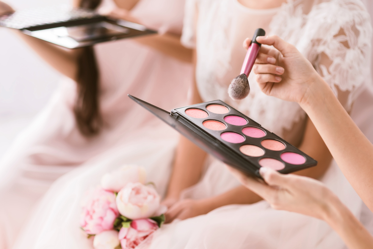 Young bridesmaid holding the palette of blusher