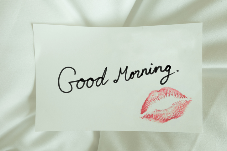 Red lips kiss Good morning on white note message on bed
