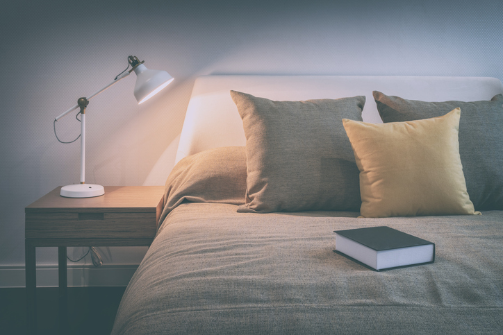 cozy bedroom interior with book and reading lamp