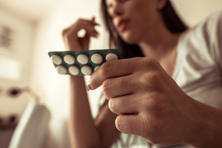 Close-up of woman's hands holding pills.