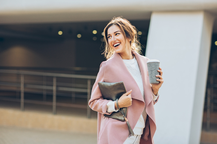 Elegant woman walking outdoors and looking back