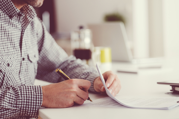 Man signing documents, unrecognizable person