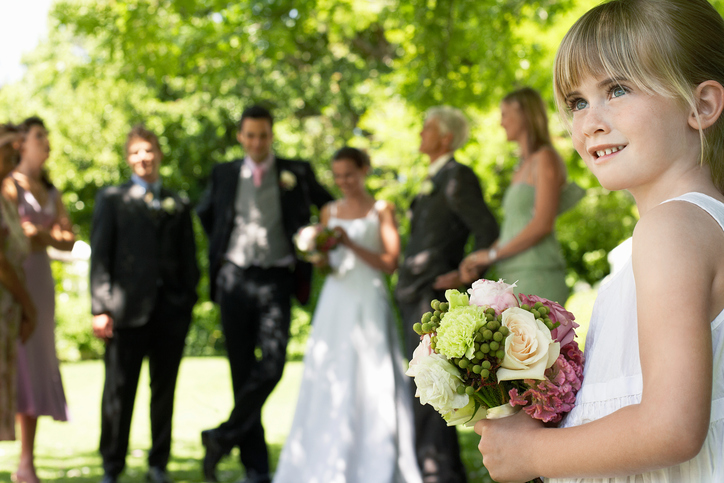 Cute Little Bridesmaid Holding Bouquet In Lawn