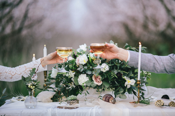 Raising glasses with champagne at the wedding table