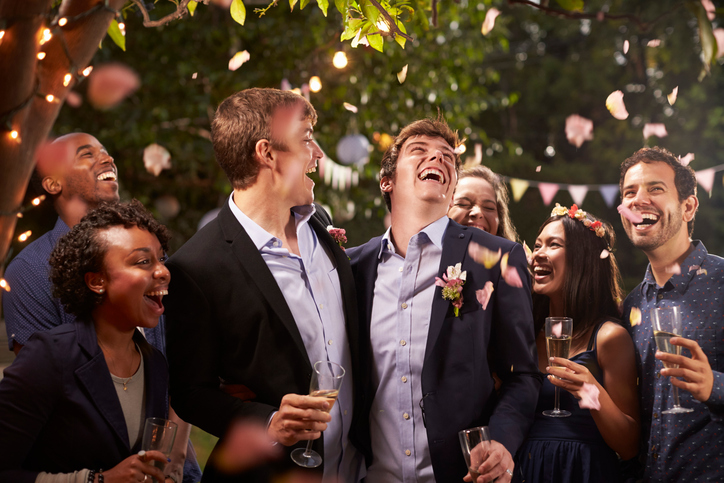 Gay Couple Celebrating Wedding With Party In Backyard