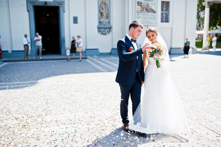 wedding couple come out from church and looked at the bouquet