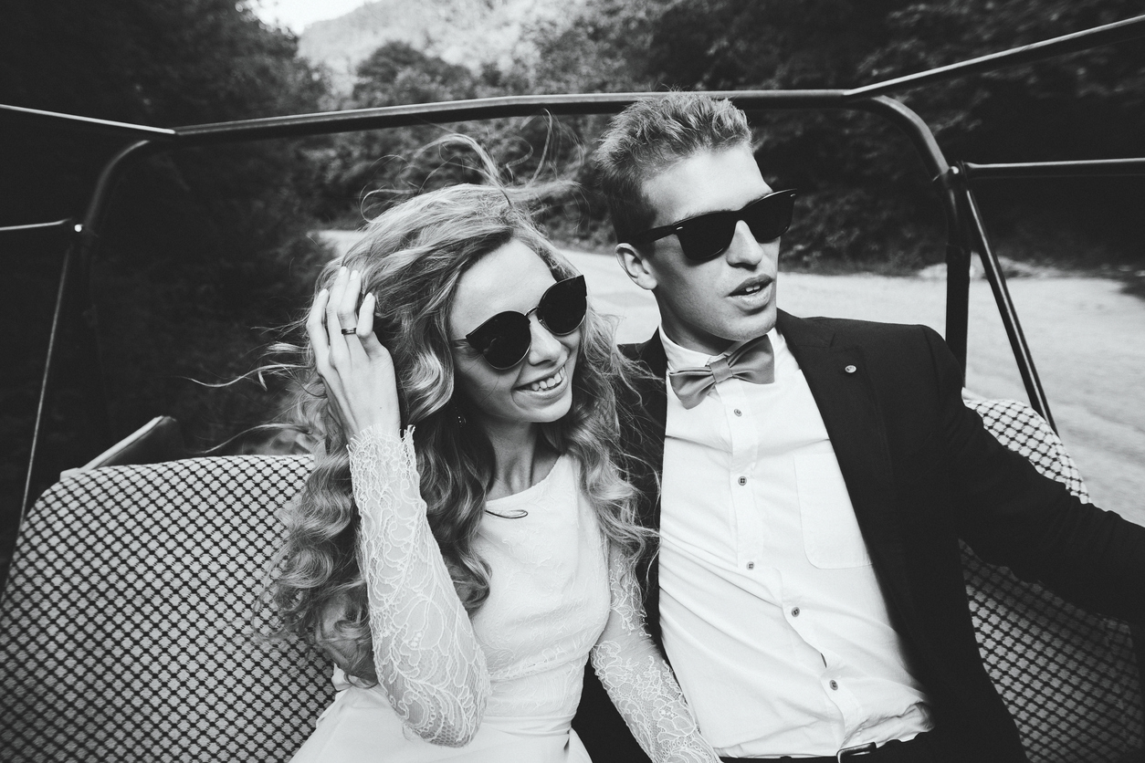 Young happe coupe in open car at speed with the wind in hair. Fashion style, bw tones